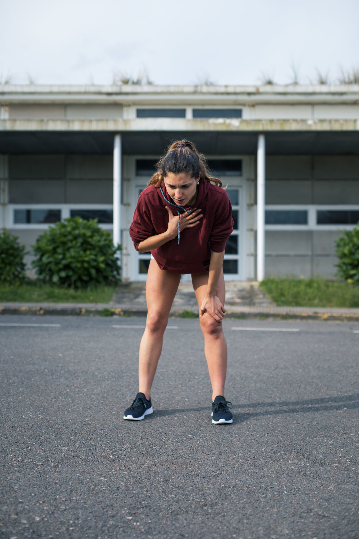 Female athlete suffering asthma attack during running training