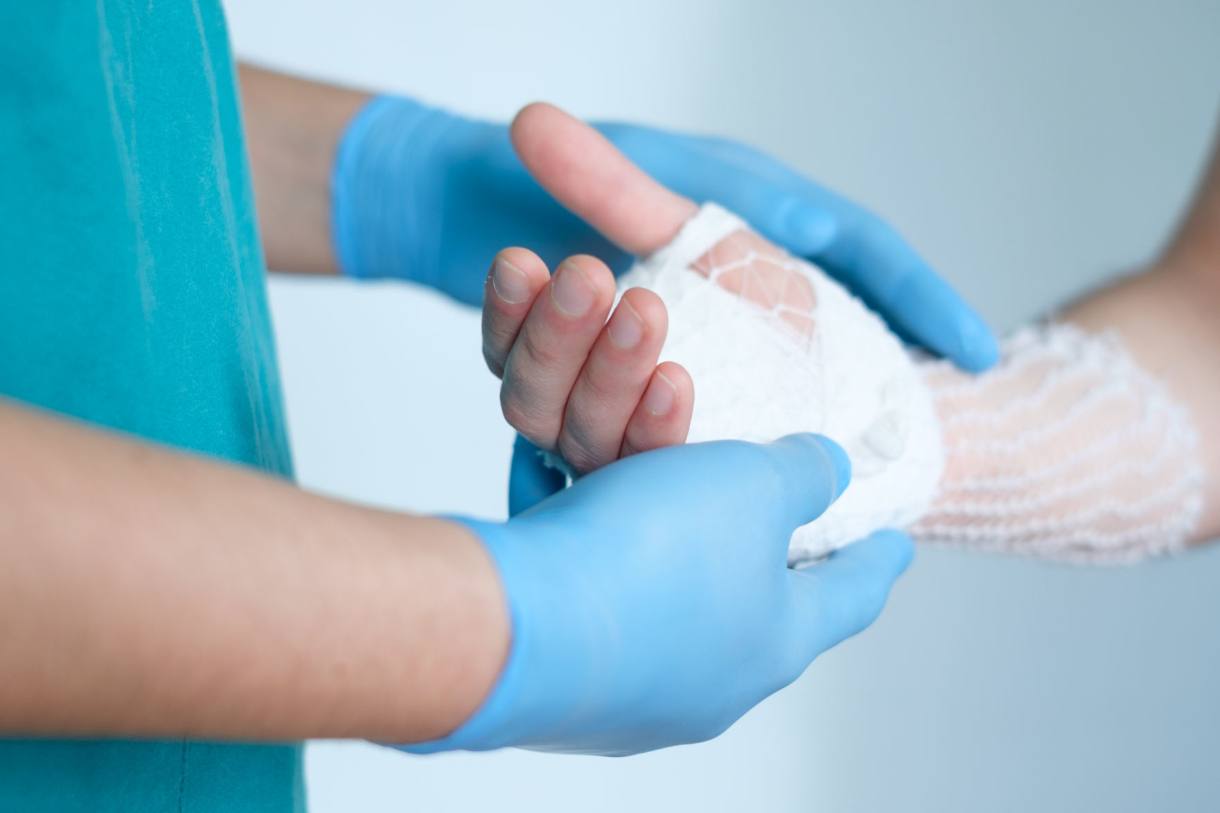 close up of doctor bandaging one hand