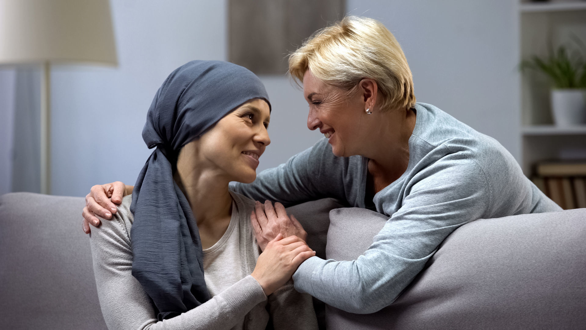 Mom supporting and hugging her daughter with cancer, visits in oncohospital